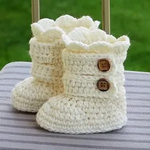 Handmade crochet baby booties in cream color with secure wooden buttons for winter